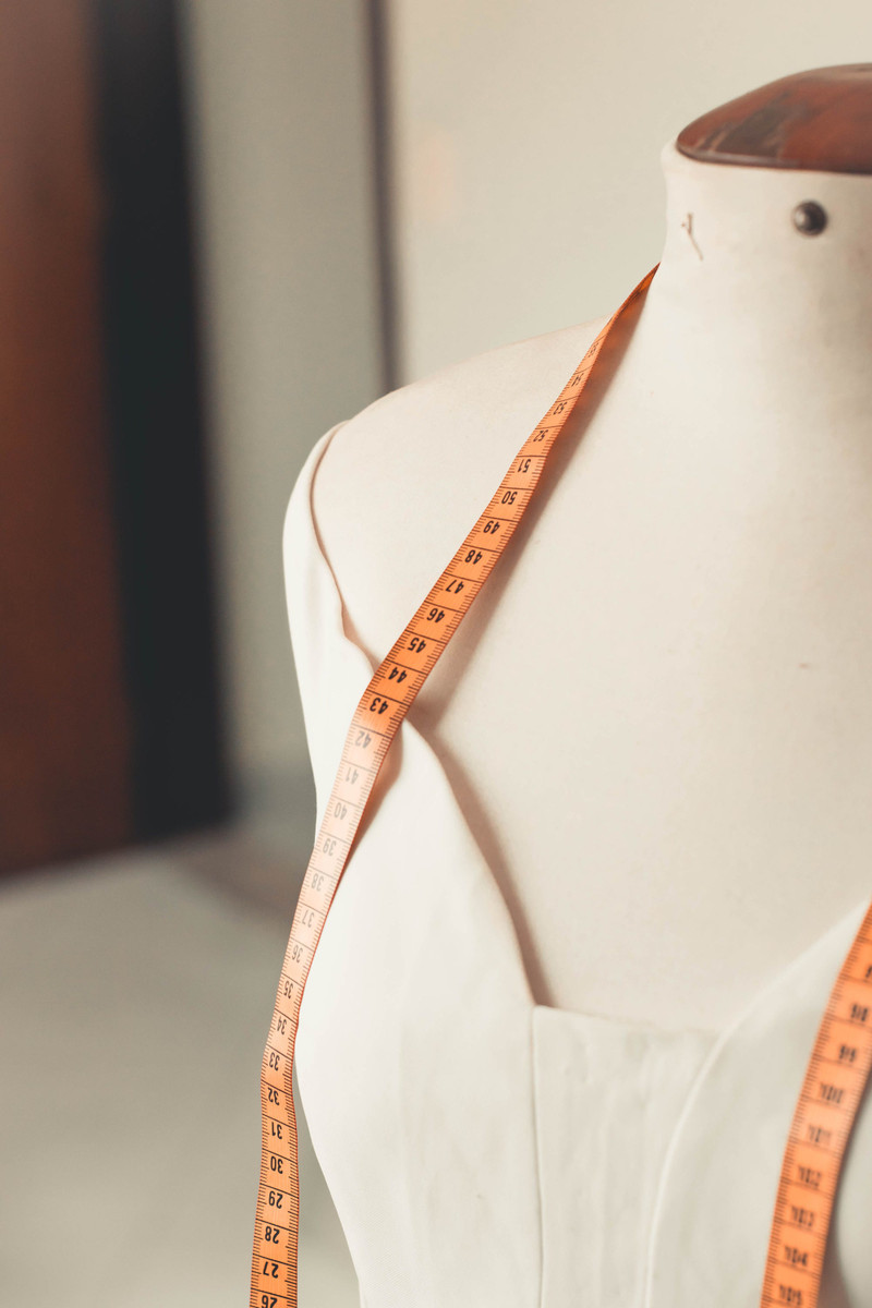 A tape measure over a dress form.