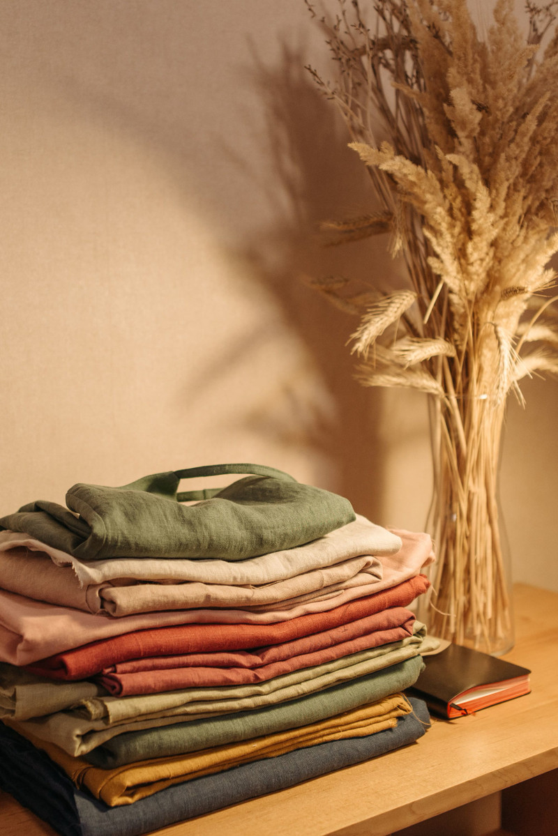 Folded linen in warm colours on a table.