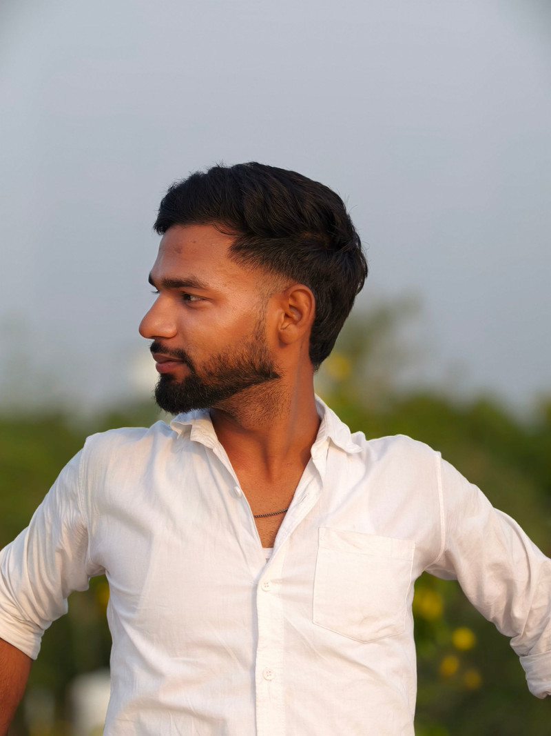 A man in a white linen shirt in evening light.
