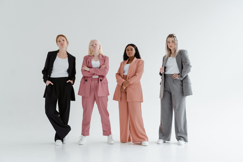 Four people in relaxed suits in a white studio.