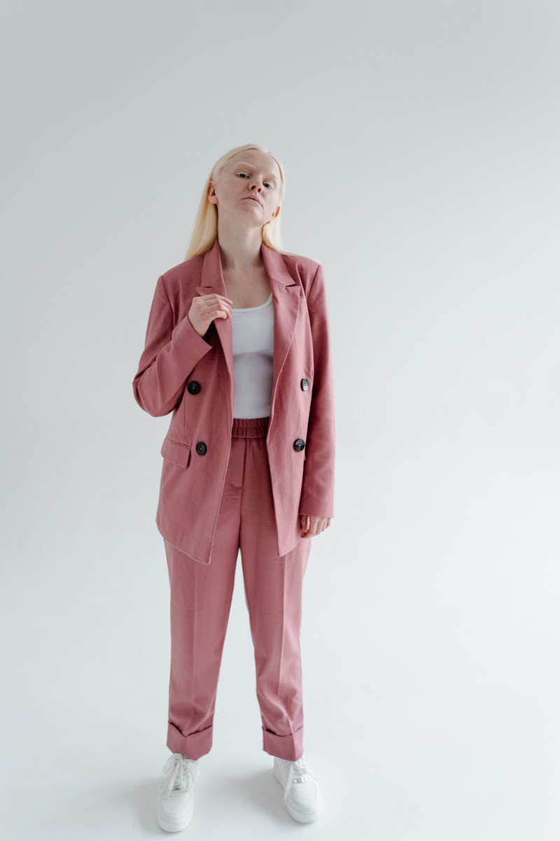A woman in a rose relaxed suit.