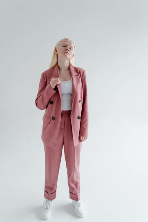 A woman in a rose relaxed suit.