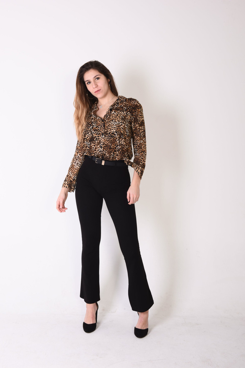 A leopard-print blouse with black flared trousers.