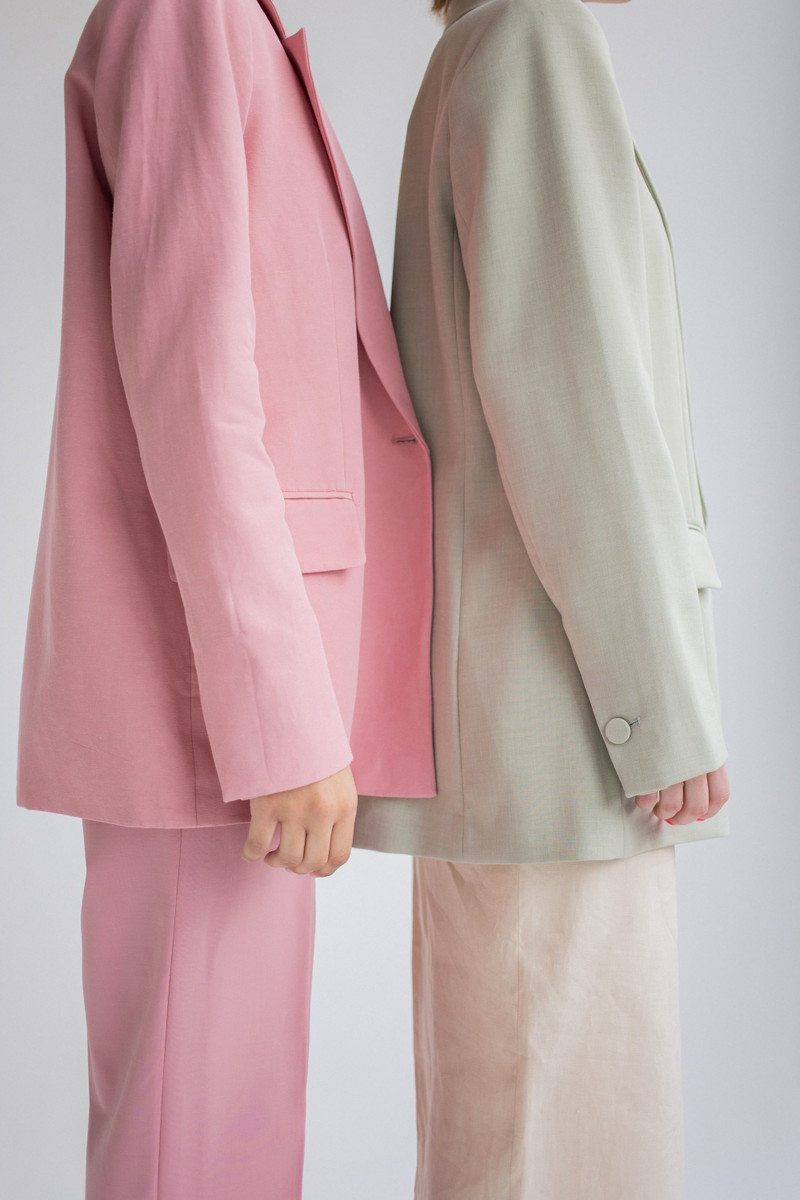 Close up of a rose and a sage blazer side by side.